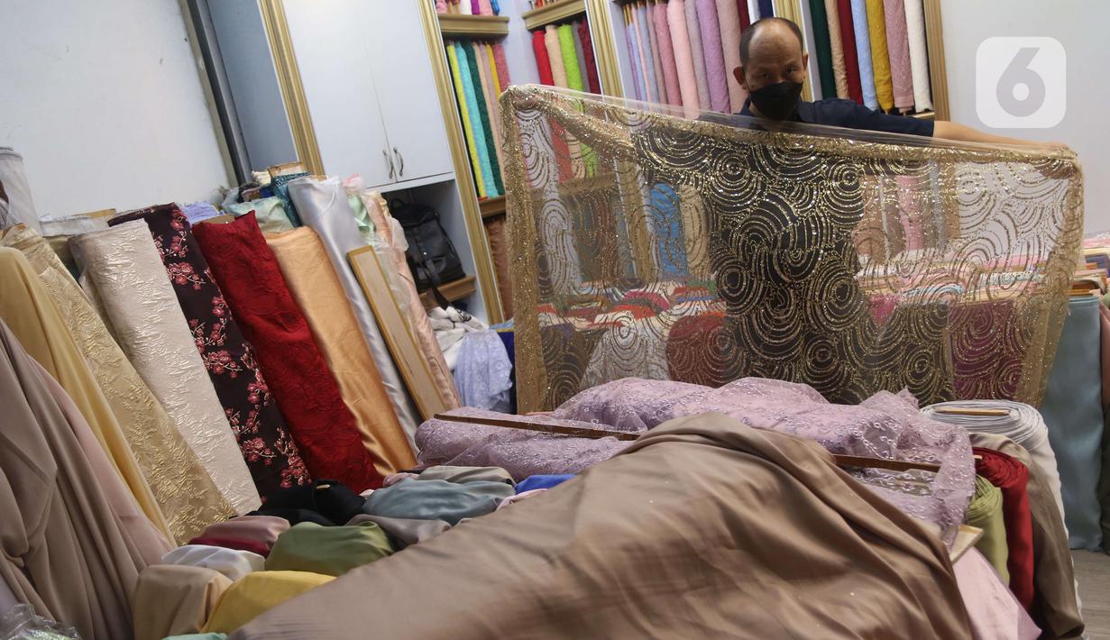 Pekerja menyusun bahan kain di Pasar Tanah Abang, Jakarta, Sabtu (27/11/2021). Utilisasi industri tekstil dan produk tekstil dalam negeri menunjukkan kinerja yang positif menjelang akhir 2021. Utilisasi industri itu berada di posisi 80 - 85 persen pada awal kuartal IV/2021. (Liputan6.com/Angga Yunia