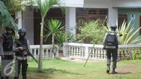 Petugas Kepolisian Brimob berjaga disekitar area rumah terduga teroris di Setu, Tangerang Selatan, Rabu (21/12). Pada saat penggerebekan, terjadi perlawanan hingga mengakibatkan tewasnya ketiga tersangka (Liputan6.com/Helmi Affandi)