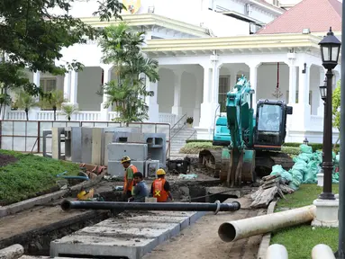 Pekerja menyelesaikan perbaikan drainase Kompleks Istana Kepresidenan, Jakarta, Senin (18/12). Presiden Jokowi memindahkan aktivitas kerja ke Istana Bogor hingga proses revitalisasi drainase lingkungan Istana di Jakarta selesai (Liputan6.com/Angga Yuniar)