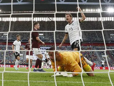 Penyerang timnas Jerman, Thomas Mueller berselebrasi setelah mencetak gol melewati kiper Latvia, Roberts Ozols dalam laga uji coba jelang EURO 2020 di Merkur Spiel Arena, Selasa (8/6/2021) dini hari WIB. Timnas Jerman memenangkan pertandingan dengan skor 7-1. (AP Photo/Martin Meissner)