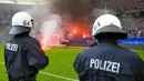 Petugas kepolisian berusaha menenangkan suporter yang mengamuk saat pertandingan antara Hamburg SV melawan VfL Borussia Moenchengladbach di Volksparkstadion, Sabtu (12/5/2018). Hamburg SV terdegradasi dari Bundesliga Jerman. (AP/Michael Sohn)