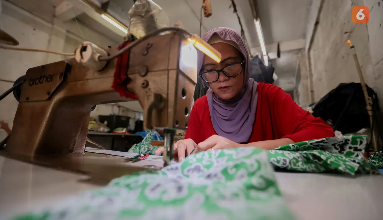 Pelaku UMKM binaan Dinas Koperasi, menyelesaikan produksi seragam sekolah di kawasan PIK Pulogadung, Jakarta, Jumat (3/7/2026). Permintaan seragam meningkat hingga kapasitas produksi mencapai 1.000 potong untuk berbagai pesanan. (Kapanlagi.com/Budy Santoso)