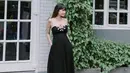 Dia mengenakan strapless dress model a-line warna hitam dengan sandal slip on warna senada. (Instagram/adieztyfersa).