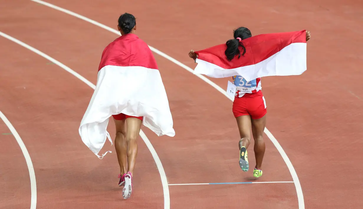 Selebrasi putri Indonesia, Rini Budiarti (kiri) yang meraih medali perak dan Triyaningsih meraih emas nomor lari 5.000m SEA Games 2015. (Bola.com/Arief Bagus)