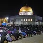 Muslim Palestina menjalani ibadah salat saat memburu malam Lailatul Qadar di luar Kubah Batu (Dome of the Rock) di kompleks Masjid Al-Aqsa di Yerusalem (8/5/2021). (AFP/Ahmad Gharabli)