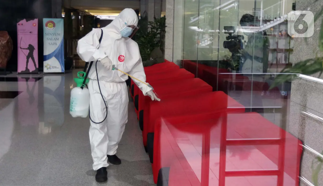 Petugas menyemprotkan cairan disinfektan di bangku tamu, Gedung Merah Putih KPK, Jakarta, Kamis (24/6/2021). Setelah 36 pegawainya terkonfirmasi positif Covid-19, KPK melakukan pembatasan kerja hingga Jumat (25/6) sebagai langkah tanggap pencegahan penyebaran. (Liputan6.com/Helmi Fithriansyah)