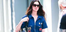Anne Hathaway tampil mengenakan jumpsuit denim dengan aksen patch. Ia membawa Tas Valentino Garavani Panthea hitam yang  diperkenalkan dalam koleksi Fall Winter 2025/2026 bertajuk Le Méta-Théâtre Des Intimités oleh Creative Director Valentino, Alessandro Michele. [Dok. Valentino]