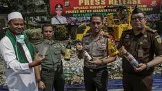 Petugas menunjukkan minuman keras sebelum dimusnahkan di Polres Jakarta Utara, Selasa (16/5). Sebanyak 16.421 botol minuman keras berbagai jenis dimusnahkan. (Liputan6.com/Faizal Fanani)