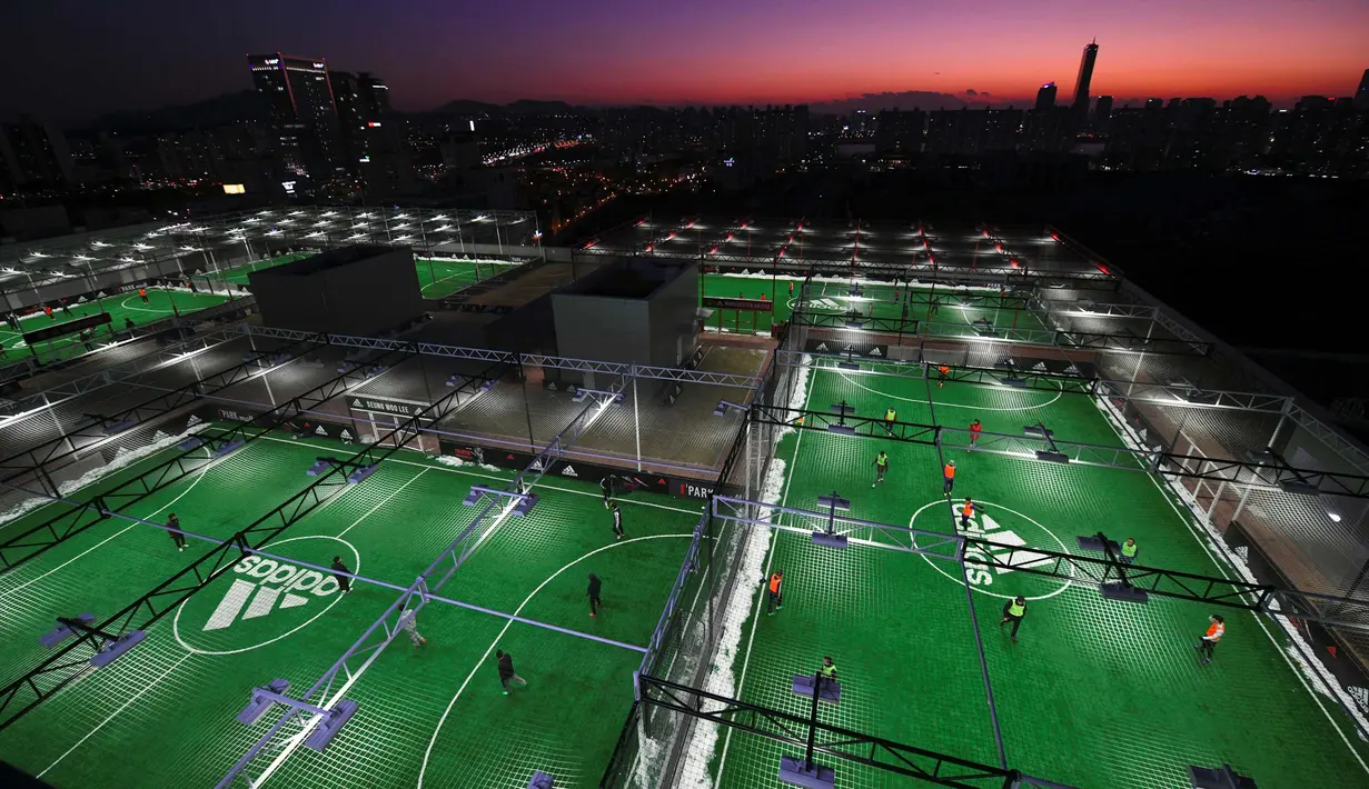 Sejumlah orang bermain bola di lapangan futsal di atap sebuah pusat perbelanjaan di Seoul, Korea Selatan (16/12). (AFP Photo/Jung Yeon-Je)