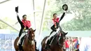 Atlet berkuda, Ferry Wahyu (kiri) dan Alfaro Menayang melakukan selebrasi kemenangan di Singapore Turf Club Riding Centre, Sabtu (6/6/2015). Tim berkuda Indonesia meraih emas di nomor tunggang serasi tim Sea Games 2015. (Liputan6.com/Helmi Fithriansyah)