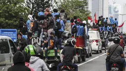 Mahasiswa menaiki sejumlah truk saat konvoi menuju Gedung DPR/MPR, Jakarta, Kamis (8/10/2020). Mahasiswa ini rencananya akan menggelar aksi menolak UU Cipta Kerja. (Liputan6.com/Johan Tallo)