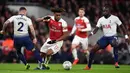 Striker Arsenal, Alex Iwobi, berusaha melewati bek Tottenham, Kieran Trippier, pada laga perempat final Piala Liga di Stadion Emirates, London, Rabu (19/12). Arsenal kalah 0-2 dari Tottenham. (AFP/Ben Stansall)