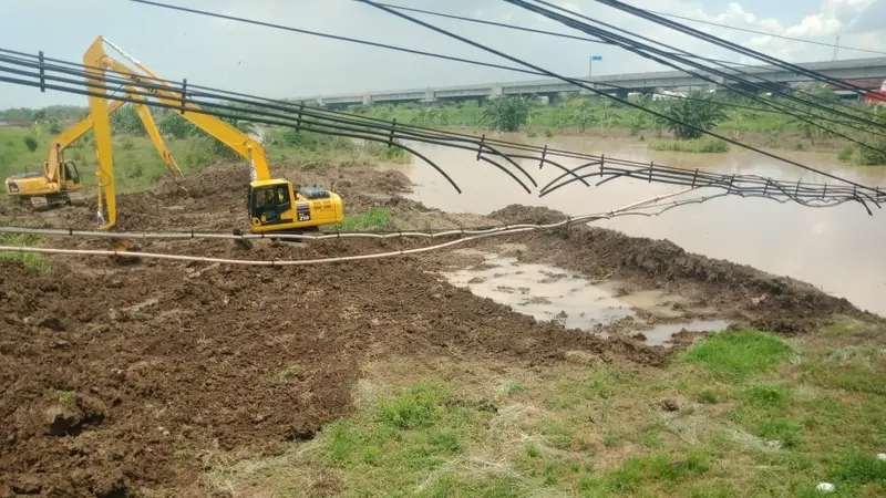 Alat berat dikerahkan untuk mengatasi banjir di Kali Lamong. (Dian Kurniawan/Liputan6.com)