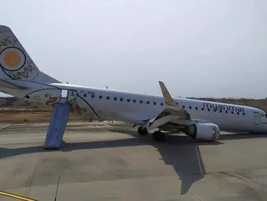 Penampakan pesawat Myanmar National Airline (MNA) yang mendarat tanpa roda depan di Bandara Internasional Mandalay, Myanmar, Minggu 12 Mei 2019. Pesawat dengan nomor penerbangan UB-103 dan bertipe Emraer-190 itu mengangkut 82 penumpang serta tujuh kru. (Aung Thura via AP)