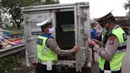 Petugas kepolisian melakukan pengecekan terhadap mobil box yang keluar Tol Merak, Banten, Senin (18/5/2020). Pemeriksaan (check point) tersebut terkait larangan mudik guna penyekatan atau memeriksa kemungkinan pemudik yang akan keluar dari wilayah Jabodetabek. (Liputan6.com/Angga Yuniar)