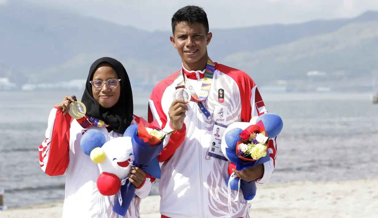 Atlet modern pentathlon, Muhammad Taufik dan Dea Salsabila, berpose usai meraih medali pada nomor beach triathle individual SEA Games 2019 di Subic, Jumat (6/12). Taufik meraih perunggu dan Dea meraih emas. (Bola.com/M Iqbal Ichsan)