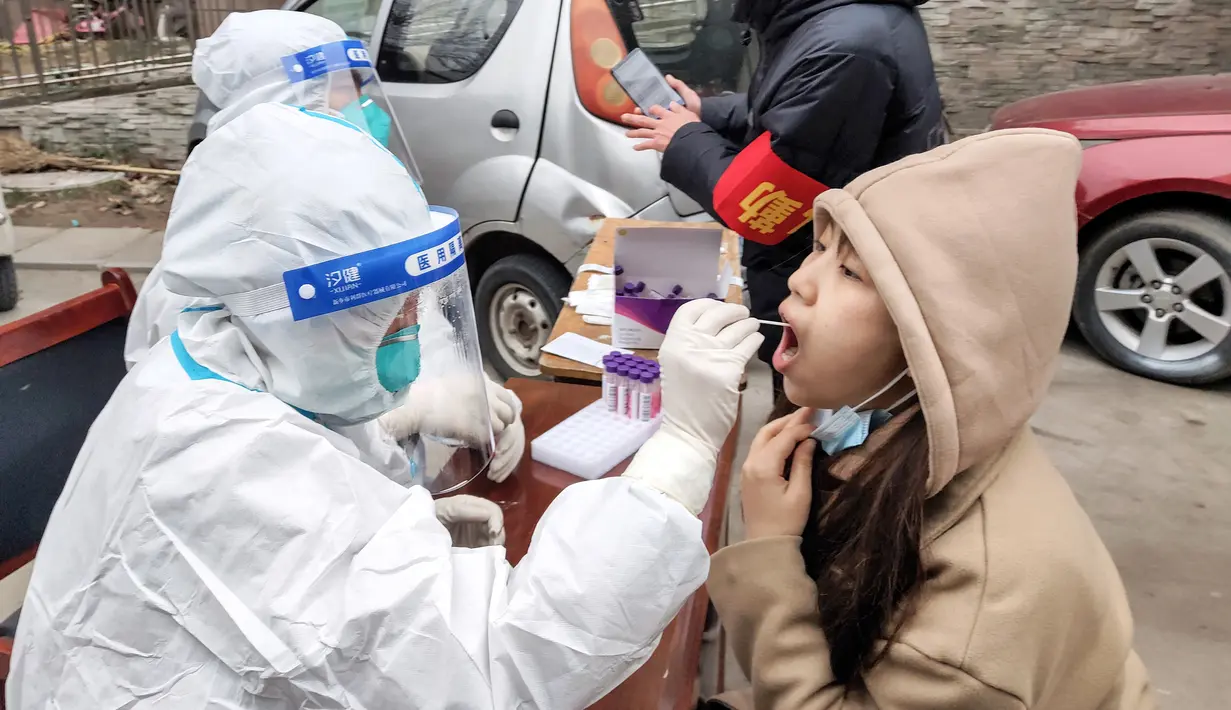 Seorang warga menjalani tes asam nukleat untuk virus corona Covid-19 di Anyang provinsi Henan pada 12 Januari 2022. China sedang berjuang melawan covid di beberapa kota, beberapa minggu sebelum Beijing menjadi tuan rumah Olimpiade Musim Dingin 2022 (STR/AFP)