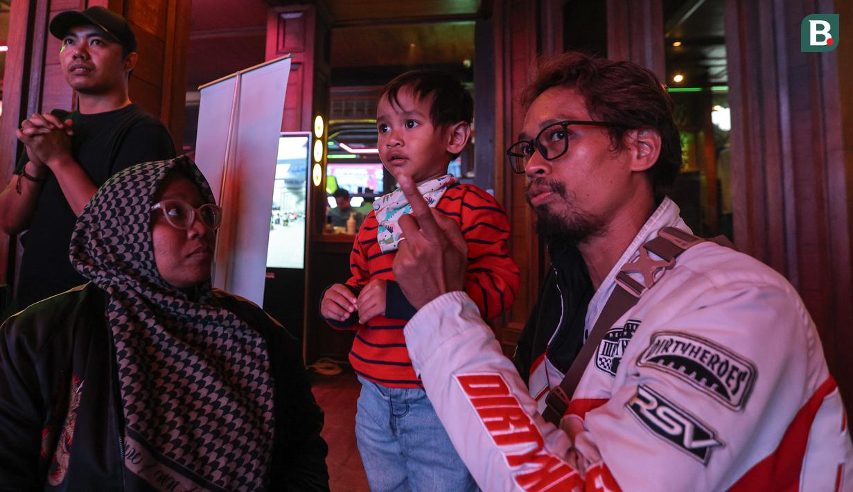 Penonton satu keluarga menyaksikan nobar MotoGP Valencia 2023 bersama Pertamina Enduro di HW Live House, Kemang, Jakarta, Minggu (26/11/2023). (Bola.com/Bagaskara Lazuardi)