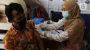 Petugas kesehatan menyuntikan vaksin COVID-19 pada warga di RPTRA Taman Gajah, Cipete Selatan, Jakarta, Kamis (27/5/2021). Pemprov DKI Jakarta melakukan vaksinasi COVID-19 bagi warga usia 18 tahun ke atas yang berada di RW rentan dan padat penduduk. (Liputan6.com/Johan Tallo)