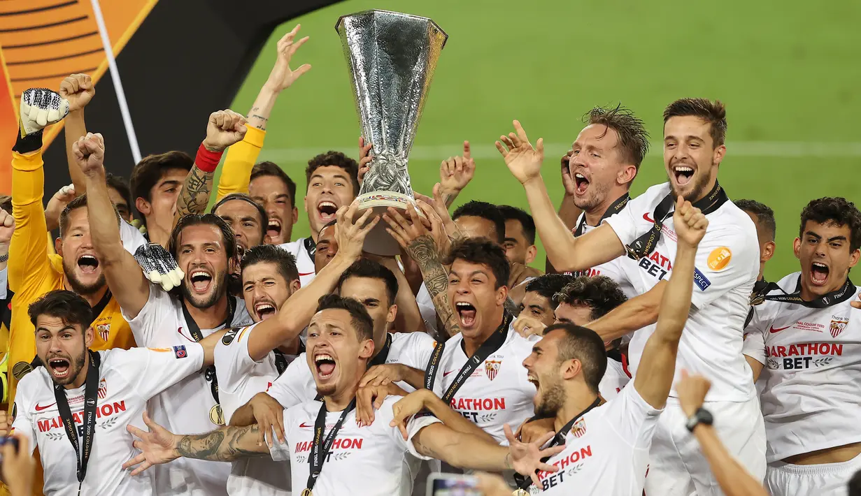 Para pemain Sevilla berselebrasi memegang trofi setelah menang atas Inter Milan pada pertandingan Final Liga Europa di Stadion Rhein Energie, Sabtu (22/8/2020) dini hari. Sevilla menjadi juara Liga Europa setelah menang dengan skor 3-2. (Lars Baron, Pool Photo via AP)