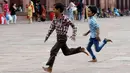 Anak-anak India bermain di masjid Masjid Jama di kawasan lama New Delhi (30/7/2019). Masjid ini didirikan oleh Kaisar Mogul, Syah Jehan, yang juga membangun Taj Mahal. (AFP Photo/Money Sharma)