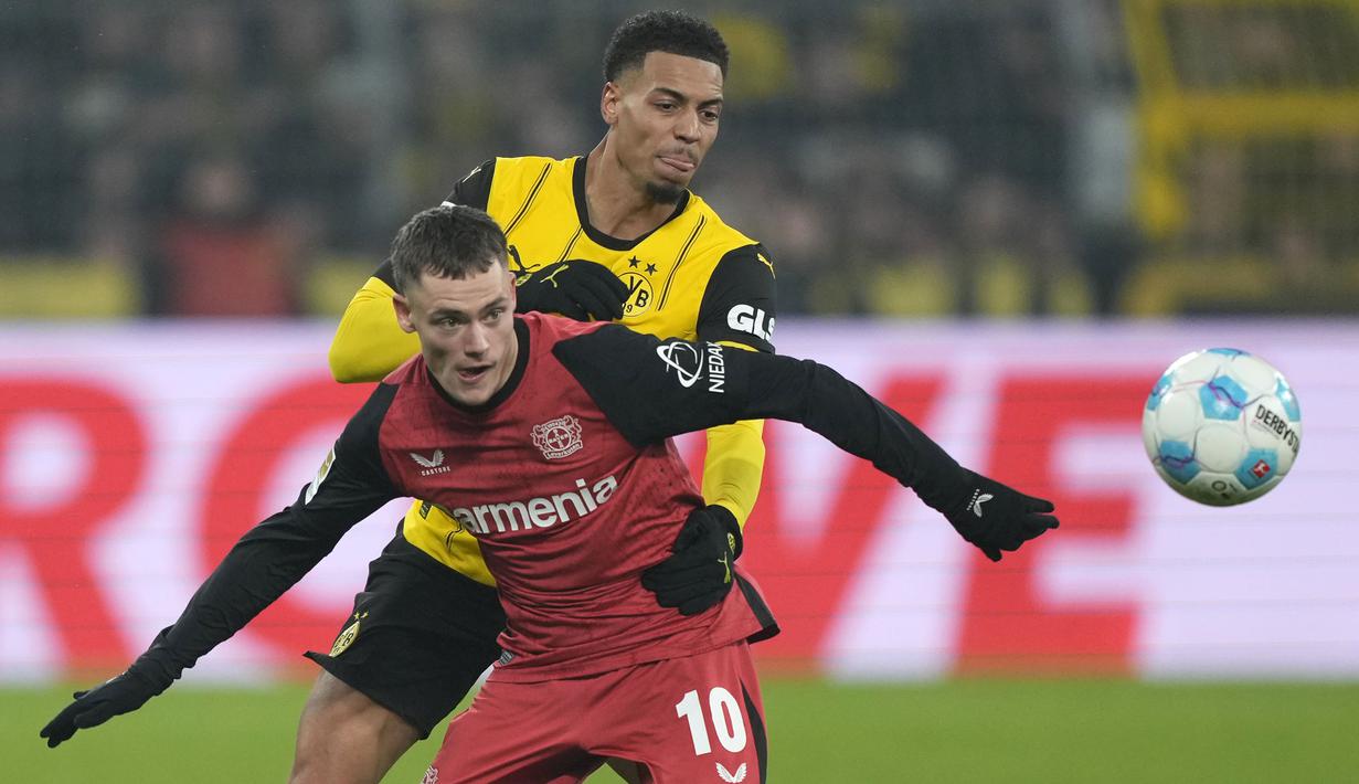 Pemain Bayer Leverkusen, Florian Wirtz (depan) berebut bola dengan pemain Borussia Dortmund, Felix Nmecha pada laga lanjutan Bundesliga 2024/2025 di Signal Iduna Park, Dortmund, Jerman, Sabtu (11/01/2025) WIB. (AP Photo/Martin Meissner)