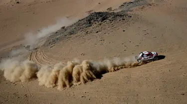 Pembalap Toyota Gazoo Racing Frenando Alonso dan Marc Coma bersaing pada stage pertama Reli Dakar 2020 antara Jeddah dan Al Wajh, Arab Saudi, Minggu (5/1/2020). Alonso mencetak sejarah sebagai juara dunia Formula 1 (F1) pertama yang berlaga di ajang Reli Dakar. (FRANCK FIFE/AFP)