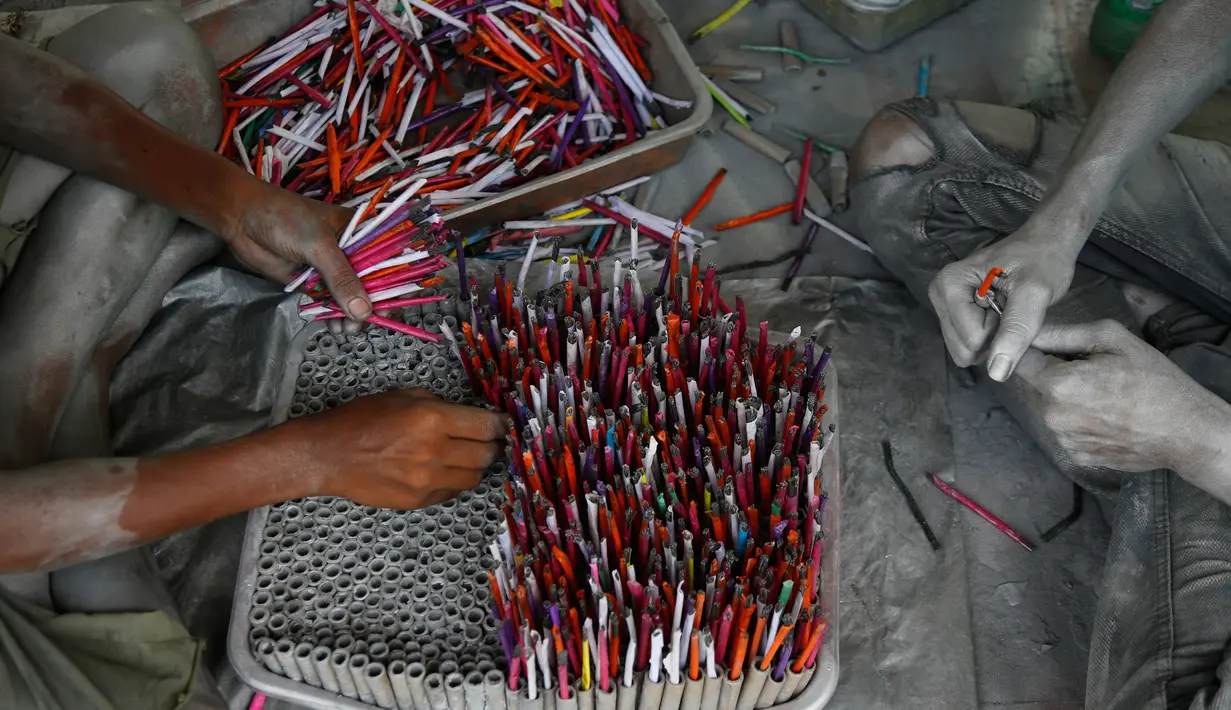 Pekerja memasukan sumbu untuk membuat petasan yang digunakan dalam festival Diwali di Ahmadabad, India (27/9). Menjelang perayaan Diwali, sejumlah produsen petasan di India dibanjiri pesanan. (AP Photo/Ajit Solanki)