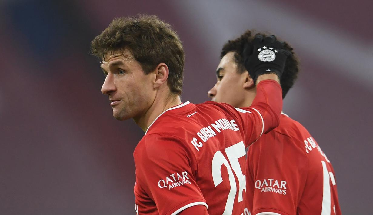 Dua pencetak gol Bayern Munich, striker Thomas Mueller (kiri) dan gelandang Jamal Musiala merayakan hasil imbang 3-3 melawan RB Leipzig usai laga lanjutan Liga Jerman pekan ke-10 di Allianz Arena, Sabtu (5/12/2020). (AFP/Andreas Gebert/Pool)