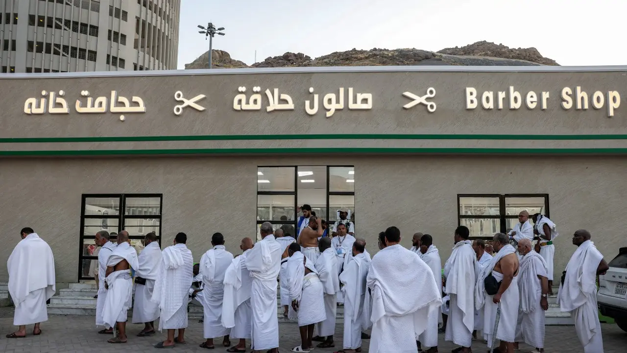Jemaah haji 2025 menunggu di luar tempat pangkas rambut untuk dipotong rambut di Mina pada 6 Juni 2025. (HAZEM BADER/AFP.)