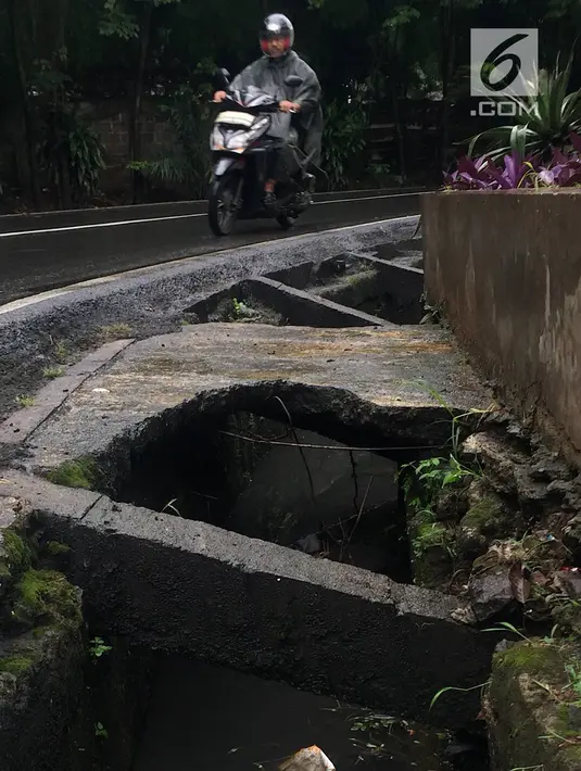 Pengendara melintas di samping selokan tanpa penutup di Jalan Mohammad Kahfi I, Jagakarsa, Jakarta, Selasa (22/1). Selain membahayakan pejalan kaki, kondisi tersebut juga berbahaya bagi pengendara terutama saat malam hari. (Liputan6.com/Immanuel Antonius)