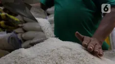 Pedagang memeriksa kondisi beras di pasar Cibubur, Jakarta, Senin (19/2/2024). (Liputan6.com/Herman Zakharia)