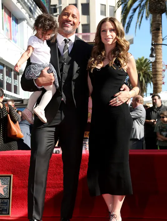 Aktor Dwayne Johnson bersama kekasihnya, Lauren Hashian dan putrinya Jasmine Johnson berpose di sebuah plakat bintang atas namanya dari Hollywood Walk of Fame di Los Angeles, Jumat (13/12). (Photo by Willy Sanjuan/Invision/AP)
