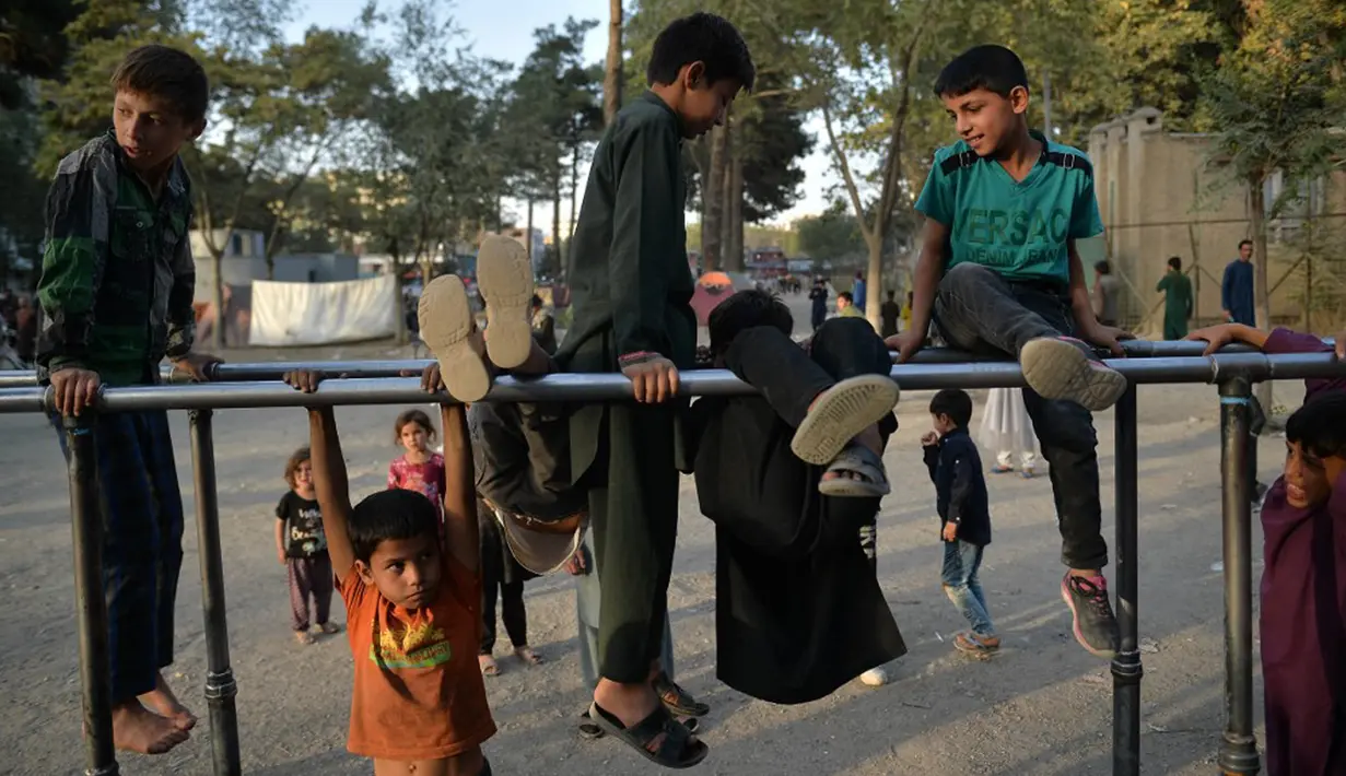 Anak-anak bermain pada palang besi yang terpasang di Shahr-e Naw Park, Kabul, Afghanistan, 9 September 2021. Taliban menguasai Afghanistan setelah pasukan Amerika Serikat meninggalkan negara tersebut. (HOSHANG HASHIMI/AFP)
