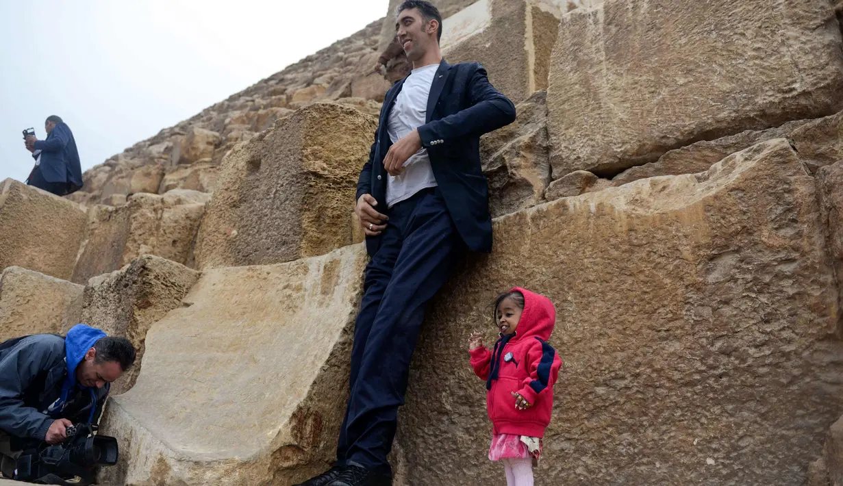 Jyoti Amge (25) dari India yang memegang rekor Guinness World Record sebagai wanita terpendek di dunia berpose dengan pria tertinggi di dunia asal Turki, Sultan Kosen (36) saat pemotretan di Mesir (26/1). (AFP Photo/Stringer)