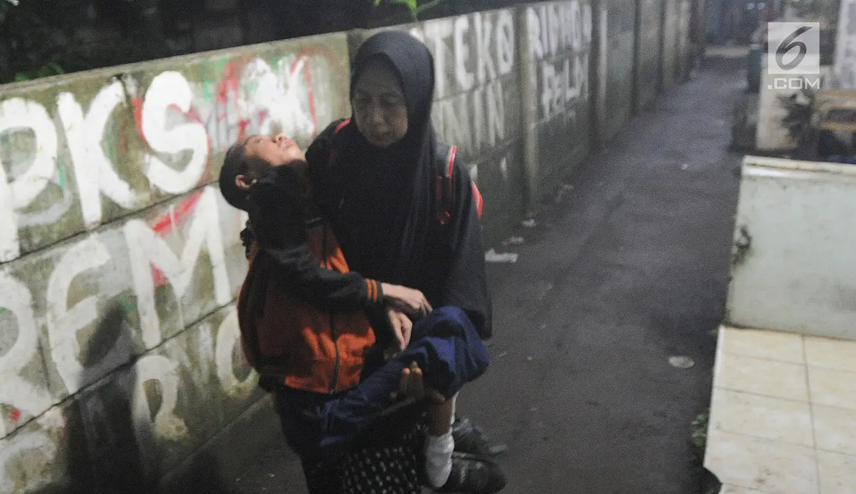 Setiap hari, Fauzan Akmal Maulana berangkat atau pulang sekolah dengan digendong oleh ibunya, Winih Utami (49). (merdeka.com/Arie Basuki)
