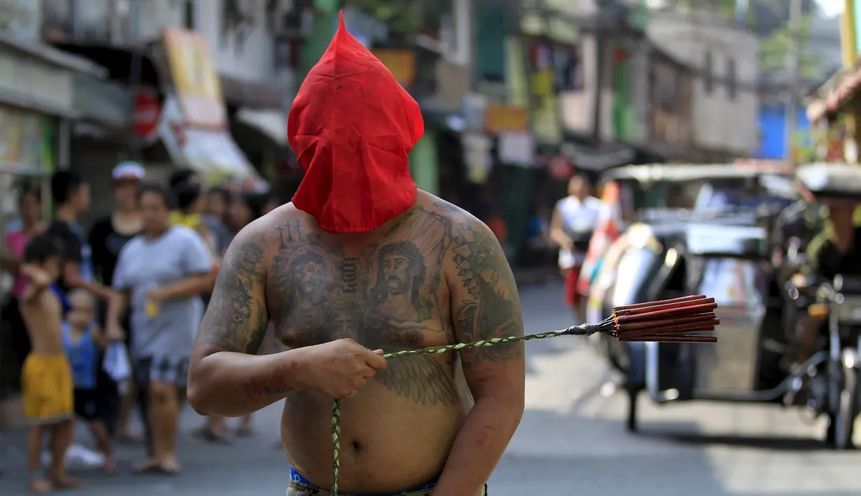 Seorang penganut Kristen Katolik Filipina berjalan sambil memakai topeng di kota Mandaluyong, Filipina, (24/3). Tradisi cambuk merupakan tradisi yang dilakukan oleh beberapa umat Katolik Filipina untuk menyambut hari Paskah. (REUTERS / Romeo Ranoco)