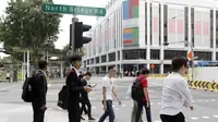 Sejumlah warga melintas di sekitar Hotel Peninsula Excelsior, Singapura, Rabu (7/11). Hotel bintang empat ini menjadi tempat menginap Timnas Indonesia jelang Piala AFF 2018. (Bola.com/M. Iqbal Ichsan)