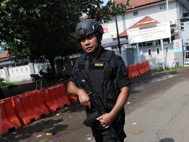 Polisi bersenjata laras panjang berjaga di dekat pintu masuk dermaga Wijayapura menuju LP Nusakambangan, Cilacap, Jateng, Kamis (28/7). 1.466 personel gabungan disiagakan untuk melakukan pengamanan eksekusi mati tahap III. (Liputan6.com/Helmi Afandi)