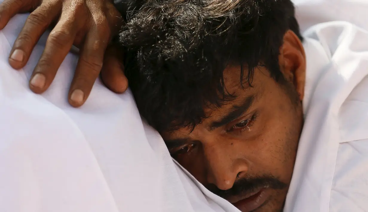 Seorang pria menangis disamping mayat gajah di Colombo, Sri Lanka, Selasa (15/3). Kematian Gajah Hemantha membawa kedukaan bagi warga setempat. (REUTERS / Dinuka Liyanawatte)