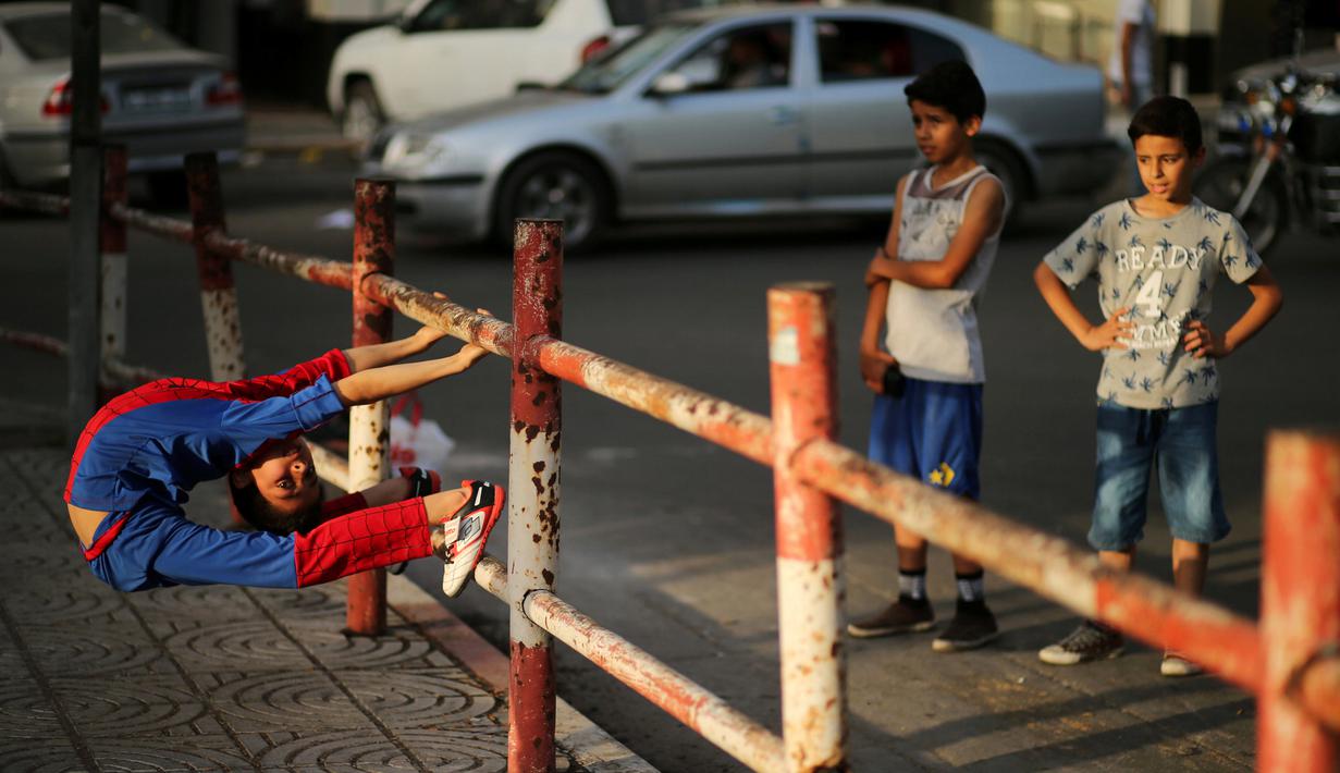 Kelenturan tubuh Mohammed al Sheikh saat menunjukkan aksinya di sebuah pantai di Kota Gaza, Palestina, Kamis (2/6). Anak laki-laki yang dijuluki Spiderboy ini mengundang perhatian masyarakat internasional karena kelenturan tubuhnya. (REUTERS/Mohammed Sale