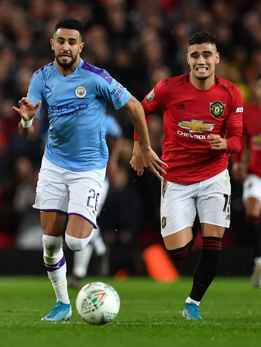 Gelandang Manchester United, Andreas Pereira dan gelandang Manchester City, Riyad Mahrez mengejar bola selama pertandingan leg pertama semifinal Piala Liga Inggris di Old Trafford (7/1/2020). City menang 3-1 atas MU. (AFP/Paul Ellis)
