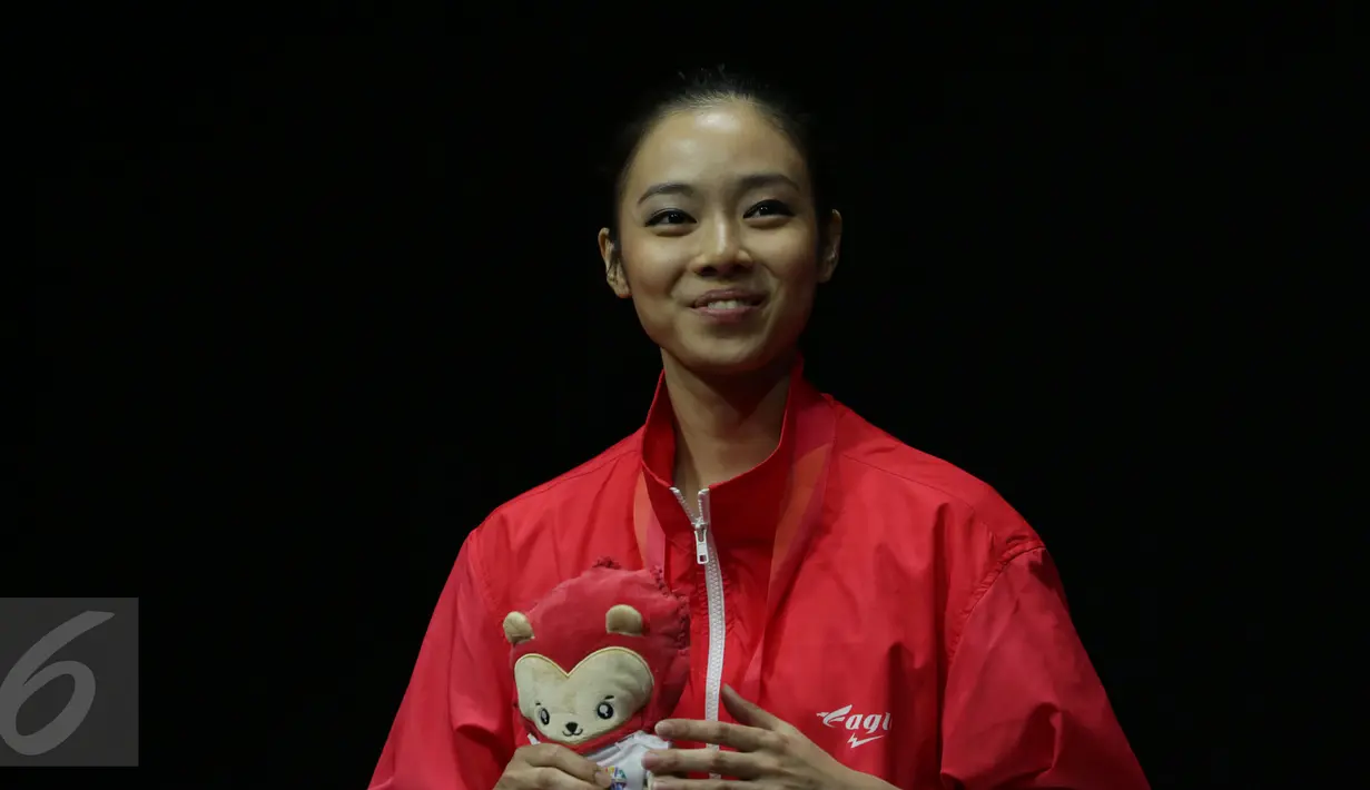 Atlet wushu Indonesia, Lindswell Kwok tersenyum jelang pengalungan medali SEA Games 2015 di SingaporeExpo, Singapura, Senin (8/6/2015). Lindswell berhasil meraih emas di nomor pedang TaijiJian dengan nilai 9.73 poin. (Liputan6.com/Helmi Fithriansyah)