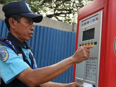 Petugas parkir melakukan transaksi pembayaran pada mesin parkir meter atau Tempat Parkir Elektronik (TPE) di Jalan Sabang, Jakarta Pusat, Senin (21/9/2015). Diduga mereka mendapatkan gaji di bawah UMP  DKI Jakarta. (Liputan6.com/Gempur M Surya)