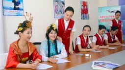 Dua orang wanita berpakaian tradisional mengikuti wawancara untuk menjadi calon pramugari di Chengdu, Provinsi Sichuan, 27 Mei 2016. Lebih dari 500 wanita cantik mengikuti sesi interview sebuah perusahaan penerbangan di Tiongkok. (REUTERS/Stringer)