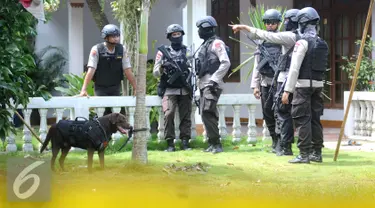 Petugas kepolisian Brimob Polda Metro Jaya mengerahkan anjing pelacak serta menyisir area tempat kejadian perkara (TKP) penggerebekan terduga teroris di setu, Tangerang Selatan, Banten, Rabu (21/12). (Liputan6.com/Helmi Affandi)