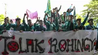 Mahasiswa memegang spanduk bertuliskan “Tolak Rohingya” saat berdemonstrasi menentang kedatangan pengungsi Rohingya di depan Dewan Perwakilan Rakyat (DPR) di Banda Aceh, Rabu (27/12/2023). Aksi diikuti oleh ratusan mahasiswa dari berbagai universitas. (CHAIDEER MAHYUDDIN/AFP)