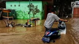 Warga melintasi banjir yang melanda kawasan bantaran kali Cisadane, Tangerang, Jumat (26/4). Banjir kiriman setinggi 2 meter sempat melanda kawasan akibat curah hujan yang tinggi di bogor membuat derasnya air mengalir jauh sampai ke tempat ini. (Liputan6.com/Johan Tallo)