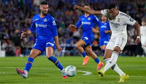 Pemain Real Madrid, Kylian Mbappe, melepaskan tembakan melewati pemain Getafe, Domingos Duarte, dalam pertandingan La Liga antara Getafe dan Real Madrid di Getafe, Spanyol, Minggu, 19 Oktober 2025. (AP Photo/Manu Fernandez)