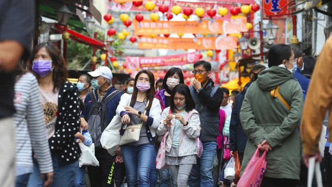 Warga memakai masker untuk mencegah penyebaran virus corona berjalan di pasar Dihua Street di Taipei, Taiwan, Rabu (10/2/2021).  Pasar Dihua Street di Taipei menjadi salah satu pasar terpopuler yang menjajakan perlengkapan Tahun Baru Imlek. (AP Photo/Chiang Ying-ying)